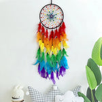 Un capteur de rêves coloré et artistique suspendu avec des plumes arc-en-ciel, créant un élément décoratif intéressant et de bon goût.