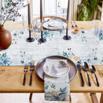 Superbe mise en scène avec un élégant service de table, des bougies et un motif floral délicat pour une ambiance chaleureuse et raffinée.