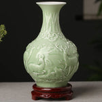 Vase décoratif en porcelaine de forme élégante avec des motifs de cerf et de végétation finement sculptés en relief sur un fond vert clair.