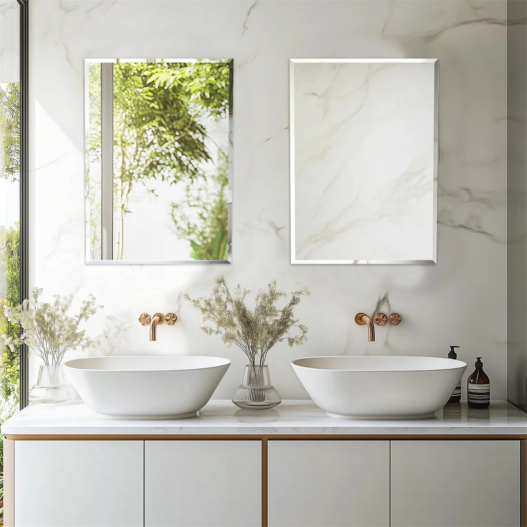 Une salle de bain moderne et épurée avec des lavabos blancs, des robinets en métal et un miroir encadré, le tout baigné d'une lumière naturelle apaisante.