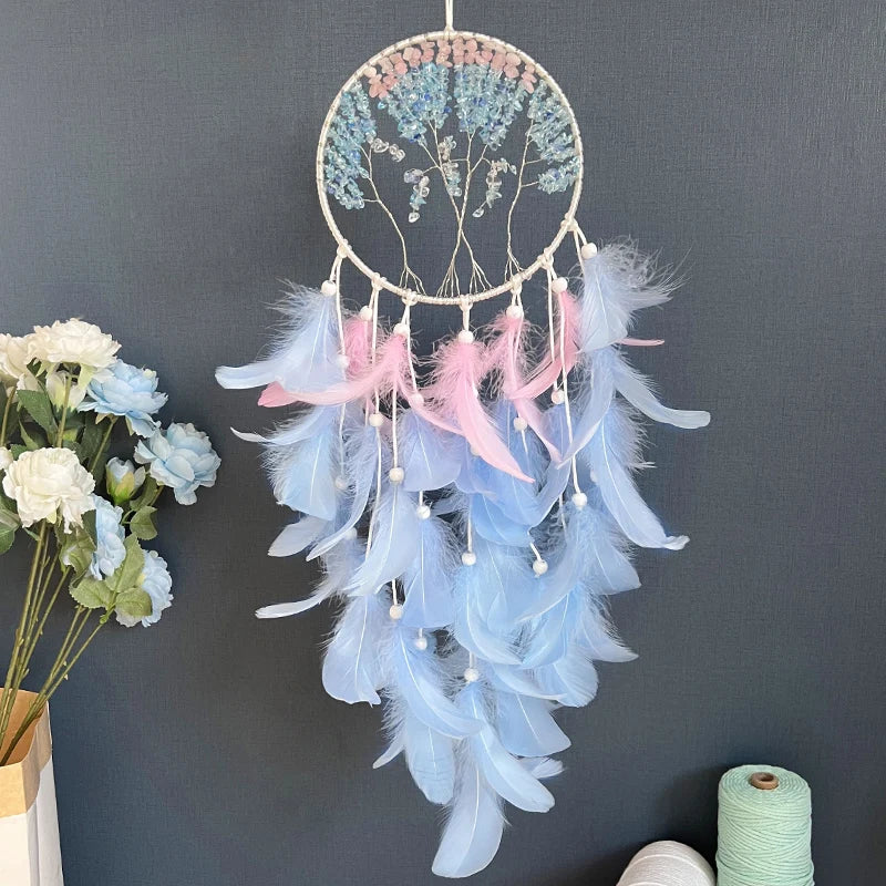 Un magnifique capteur de rêves circulaire orné de plumes bleues et roses, suspendu sur un fond noir, entouré de bouquets de fleurs.