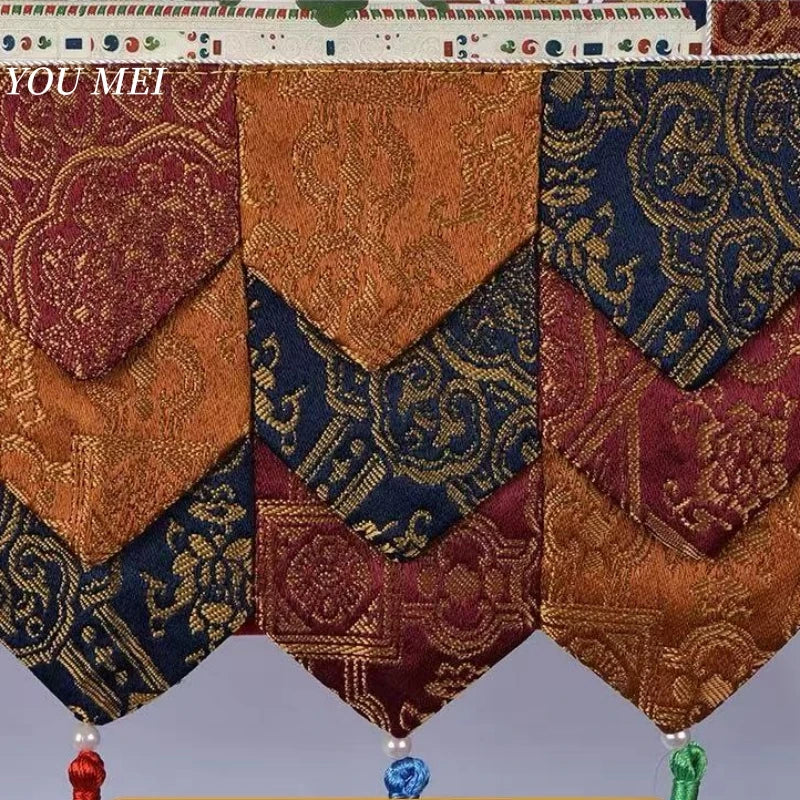 tapisserie décorative bouddhiste brodée motifs religieux ornements floraux pompons clips métalliques bleu rouge or