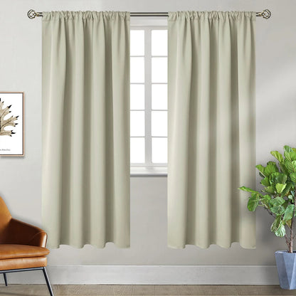 Paire de rideaux occultants beiges entièrement tirés, avec une plante verte en pot et une déco murale minimaliste.