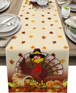 L'image montre une nappe de table de style automnal avec des feuilles d'érable multicolores, une composition de citrouilles, de maïs et un dindon stylisé portant un chapeau de pèlerin pour la fête de Thanksgiving.
