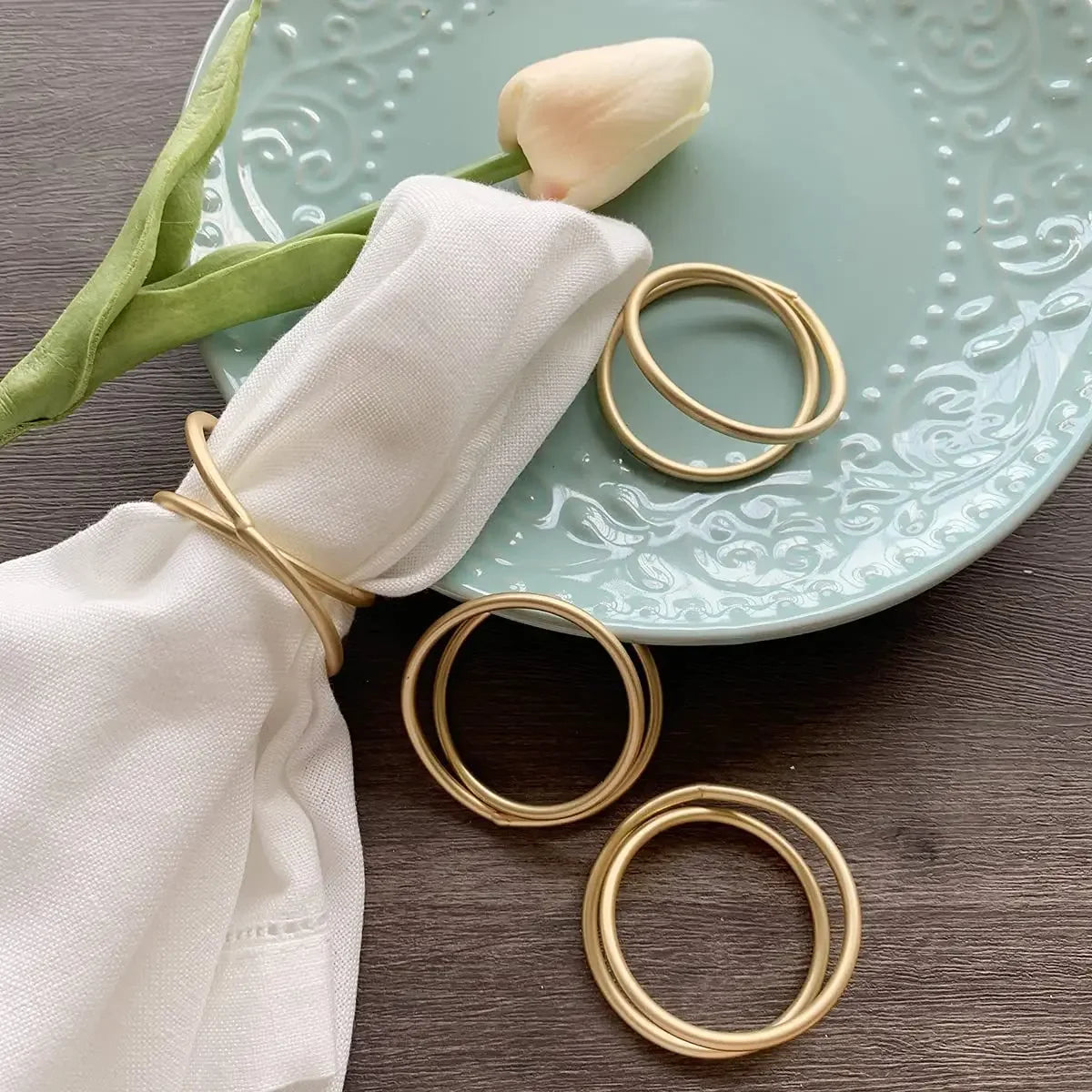 Ronds de serviette dorés avec serviette blanche
