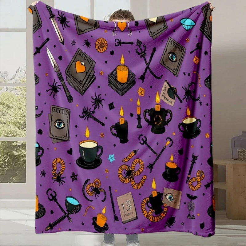 Couverture molletonnée ornée de motifs gothiques et occultes en violet, incluant des bougies allumées, des clés, des araignées et des symboles ésotériques, créant une ambiance mystique et mystérieuse.
