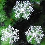 Flocons de neige suspendus sur une branche de sapin
