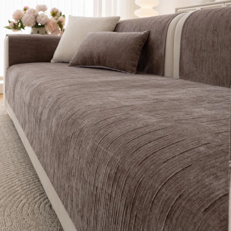 Le canapé confortable en gris foncé avec de nombreux coussins s'intègre harmonieusement dans le décor lumineux.