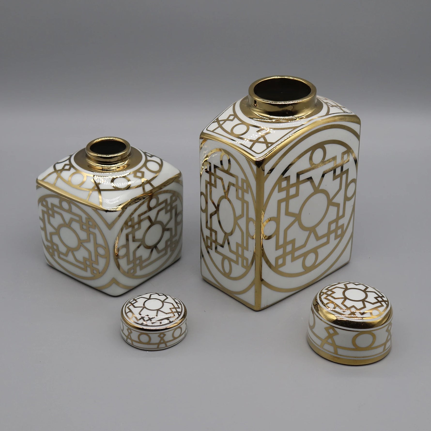 Ensemble de boîtes décoratives en porcelaine blanche et dorée avec des motifs géométriques élégants.