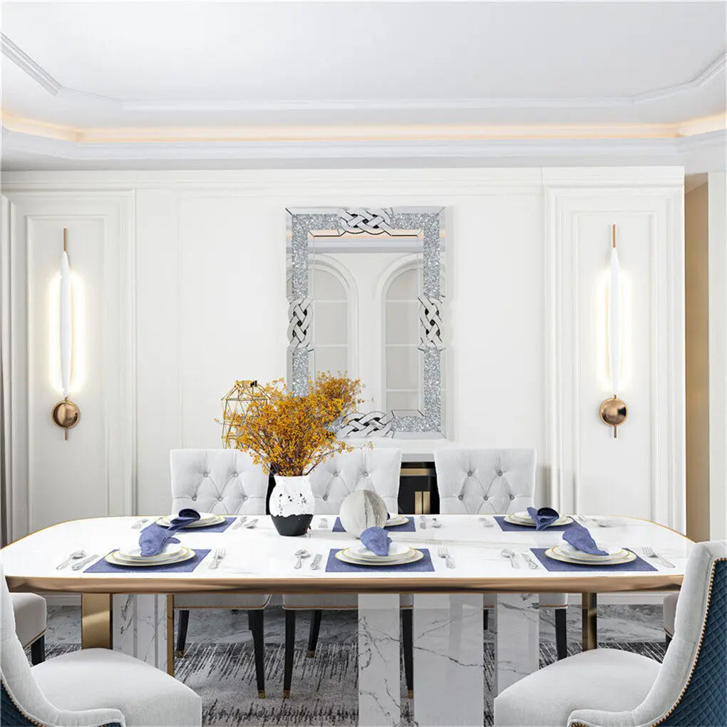 Intérieur élégant de salle à manger avec table de style moderne, miroir décoratif et luminaires appliques.
