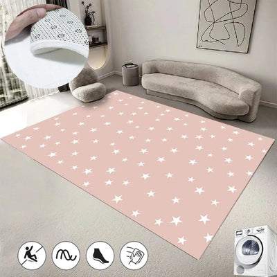 Un tapis rose à motifs d'étoiles blanches, agrémenté de coussins gris, d'une lampe suspendue et d'un canapé confortable, créant une ambiance chaleureuse et apaisante dans cette pièce.