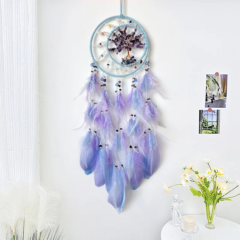 Un capteur de rêves en plumes de couleurs douces, avec des perles et une structure en forme de cercle, suspendu au mur.