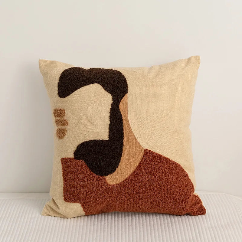 Un coussin décoratif orné de motifs géométriques en tons neutres, reflétant un style minimaliste et moderne.