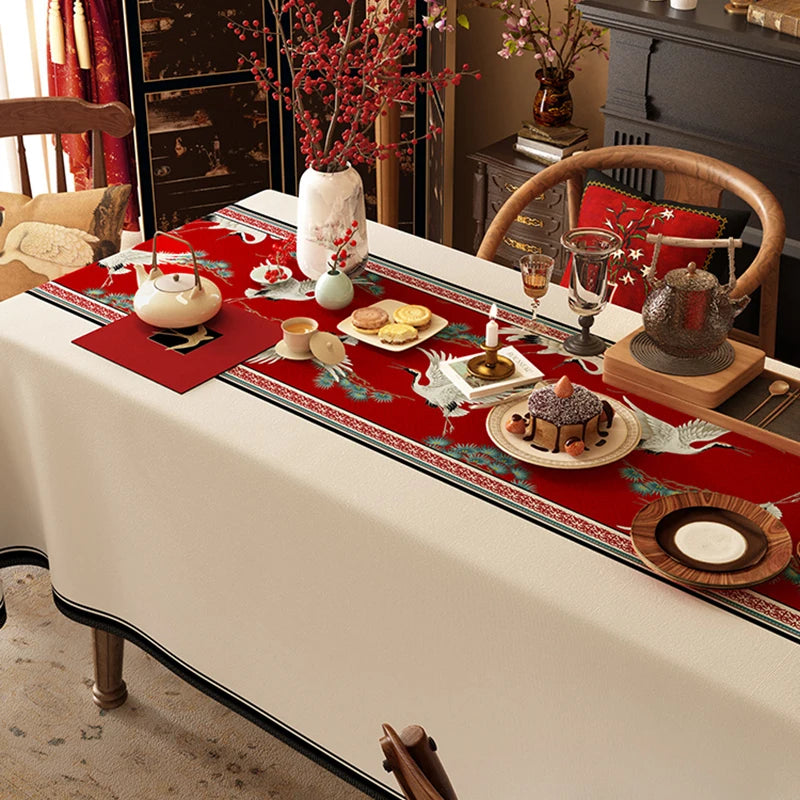 La table est joliment dressée avec des éléments décoratifs de style traditionnel, comme des fleurs rouges, des bougies et des plats de dessert, créant une atmosphère chaleureuse et conviviale.