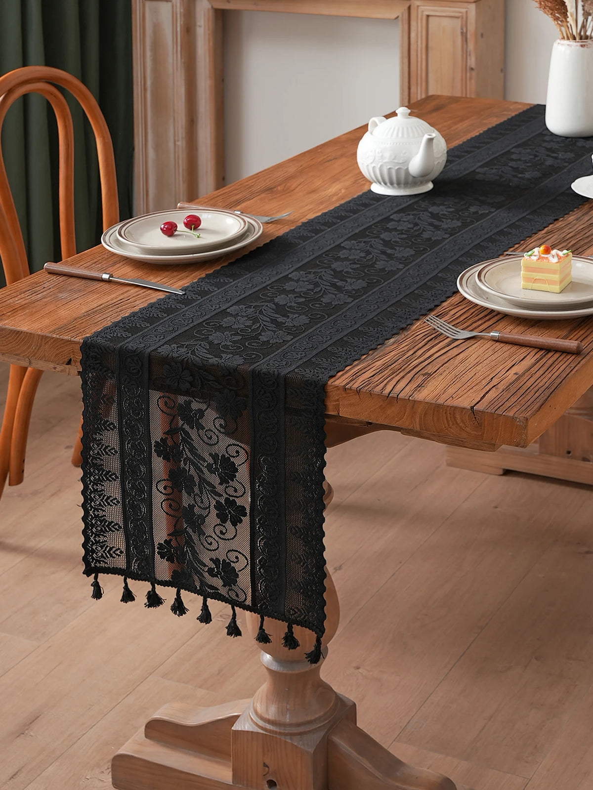 chimene table noir dentelle motif floral bordures franges assiettes couverts tasse théière gâteau cerises