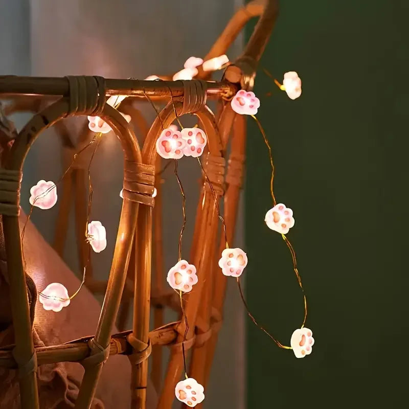 Guirlande lumineuse patte de chat rose décorant un mur de salon