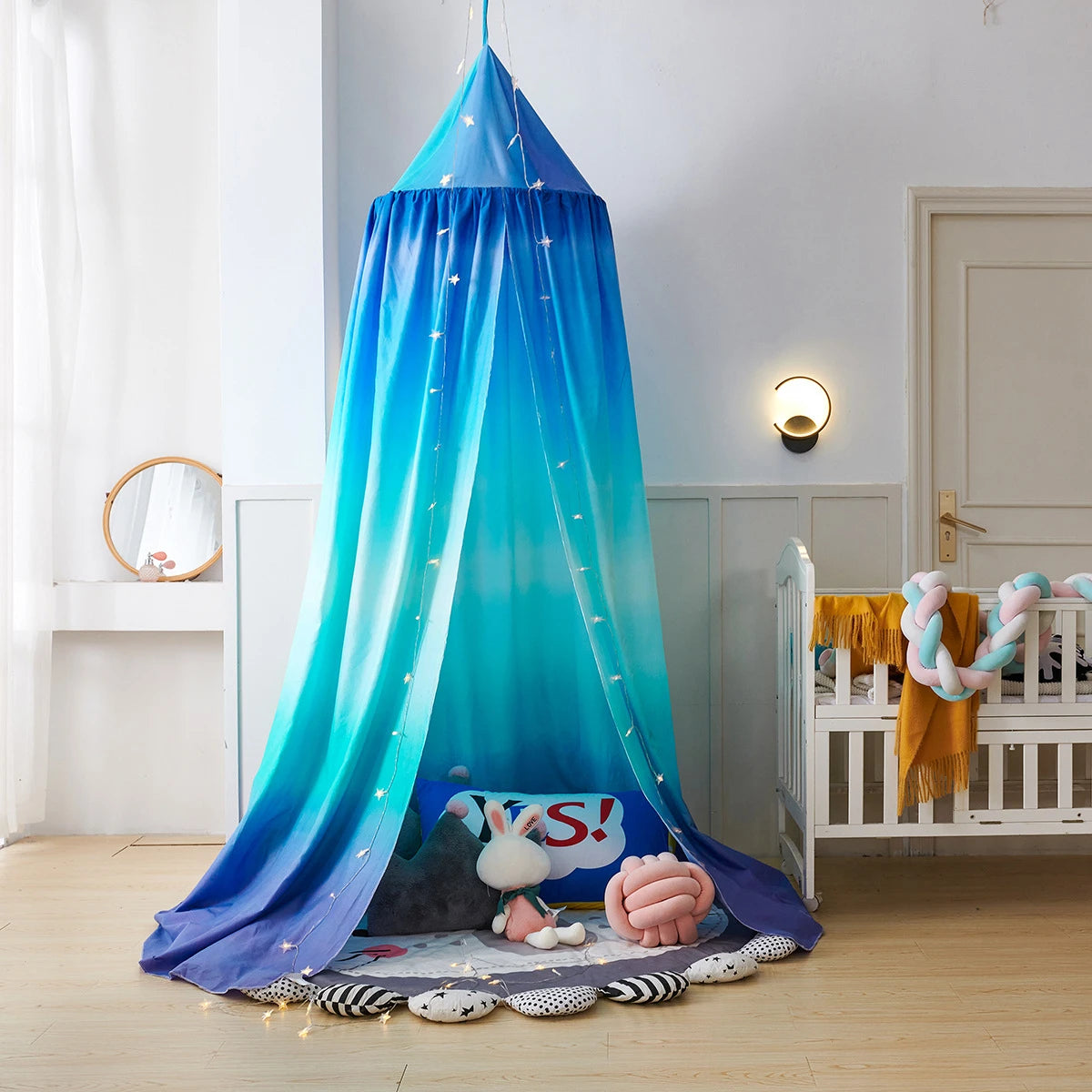 Une magnifique tente de chambre décorée d'un motif d'étoiles, avec des jouets moelleux et des accessoires, créant un environnement cocooning et ludique pour les enfants.