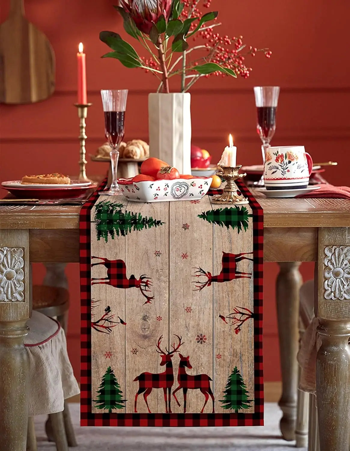 Une décoration de table festive avec des détails rustiques en bois, des fleurs rouges et des bougies, créant une ambiance chaleureuse et invitante pour les fêtes.