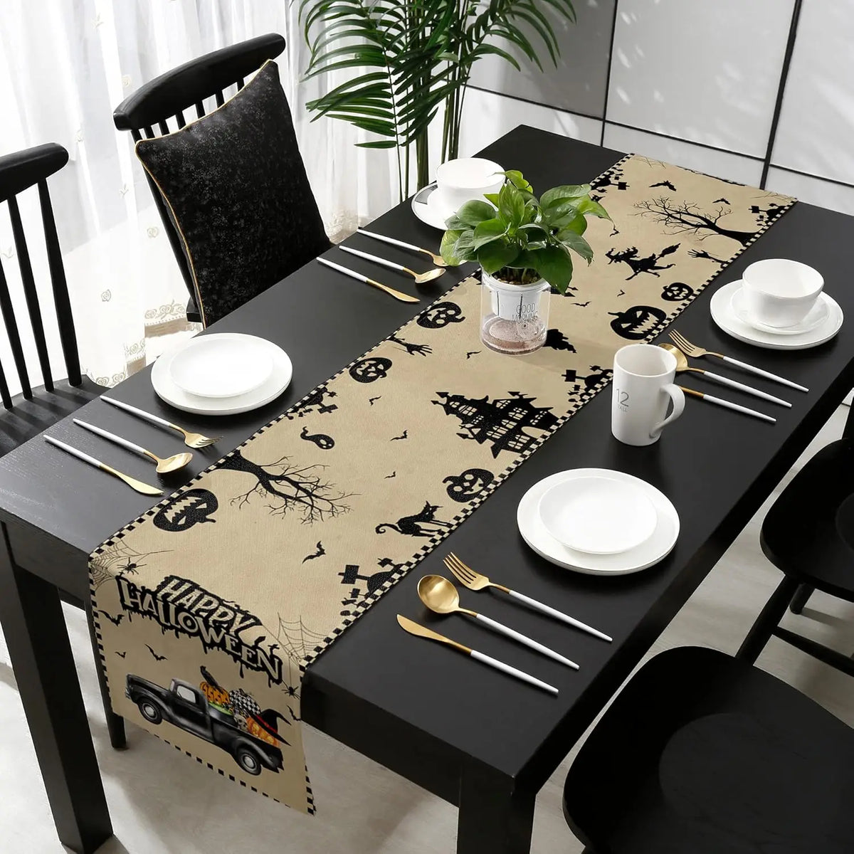 Table de salle à manger noire décorée pour l'Halloween avec motifs de citrouilles, de chats noirs et de sorcières sur la nappe assortie.