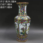 Vase de porcelaine chinois décoré de fleurs et de motifs colorés sur un fond sombre.