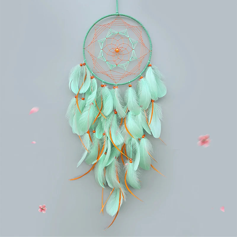 Un magnifique attrape-rêves avec des plumes mint délicates suspendues autour d'un motif géométrique vert.