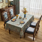 Une salle à manger élégante avec une table en bois sombre, des chaises rembourrées noires et un buffet décoré de motifs floraux, accompagnés de décors et accessoires de style vintage.