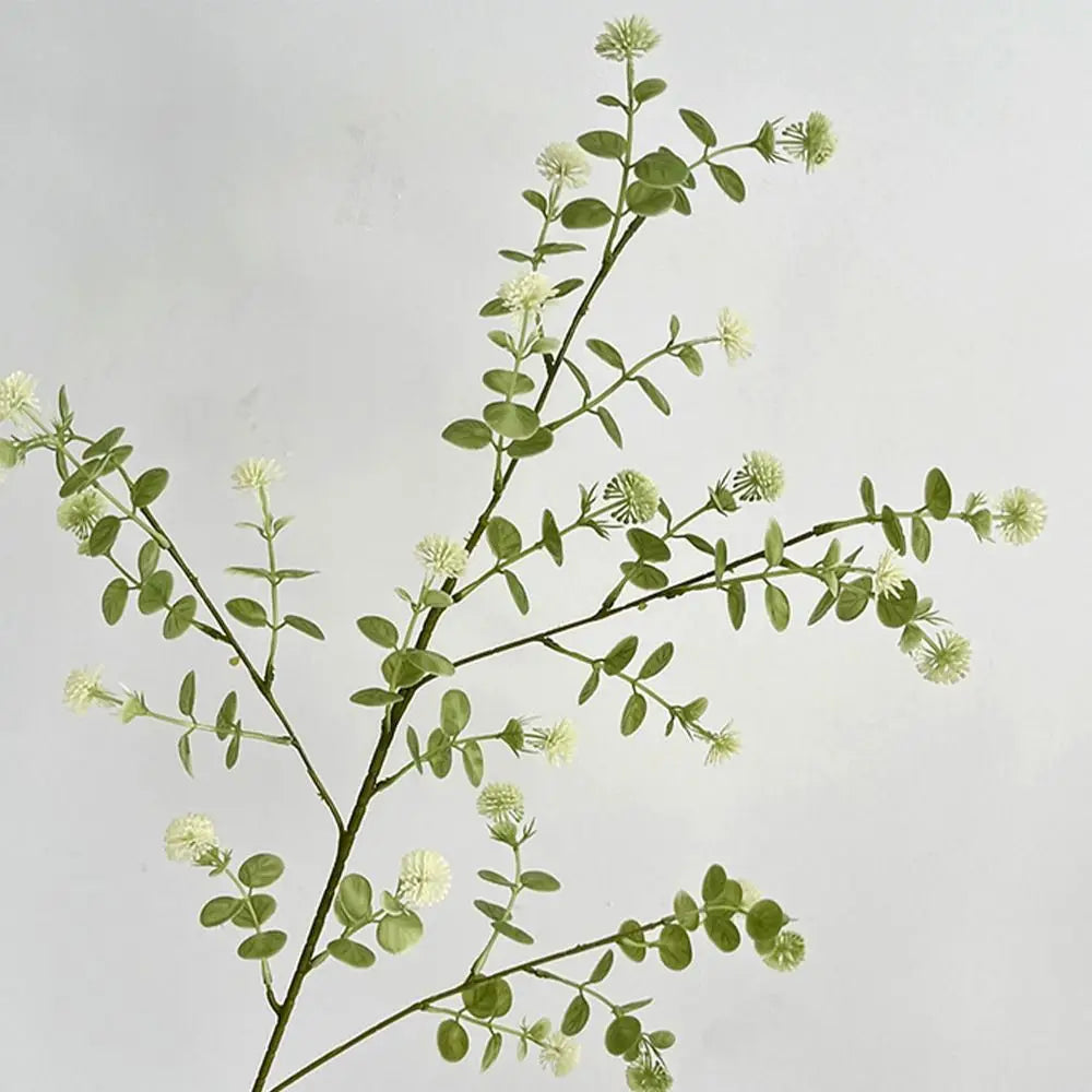 branche artificielle verte vase transparent extérieur naturel minimaliste feuilles ovales fleurs blanches exposition anniversaireDecorationJardinFeteMaison