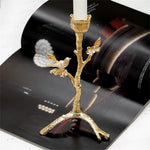 Une représentation artistique élégante d'un oiseau perché sur une branche dorée, créant une composition visuelle raffinée.