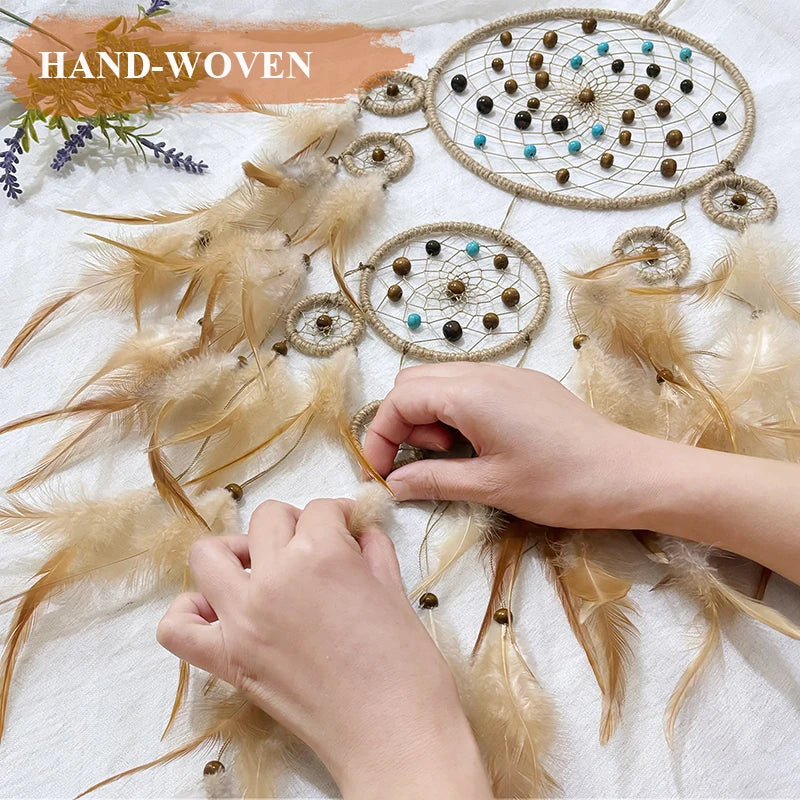 Des attrape-rêves artisanaux décorés de plumes et de perles, sur une surface texturée, suggérant l'artisanat et la créativité.