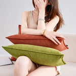 Une femme se détend avec des oreillers colorés sur un canapé.