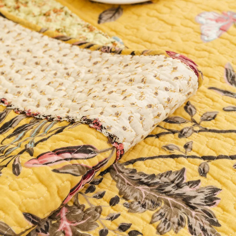 Une couverture en tricot jaune ornée de motifs floraux et de textures en relief crée une ambiance chaleureuse et accueillante.