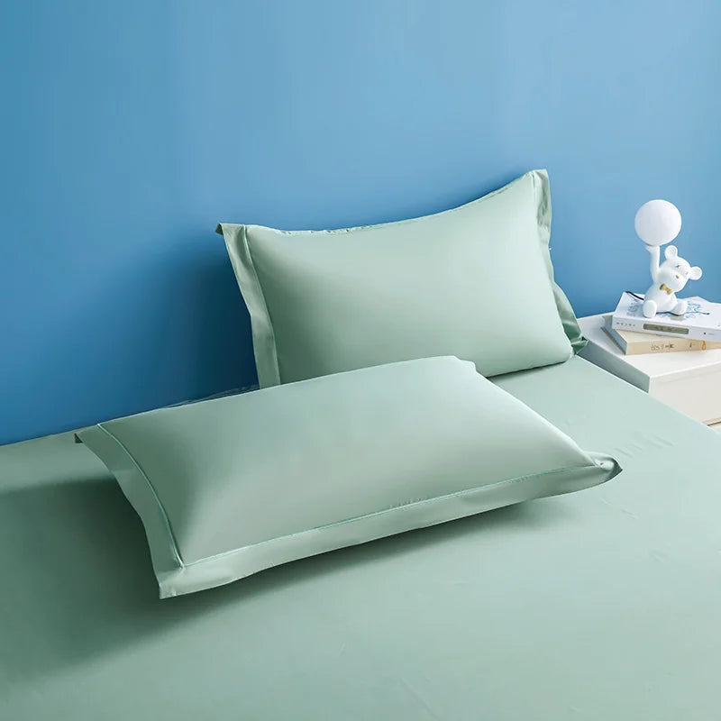 Deux oreillers élégants en velours vert pastel reposent sur un sol bleu, créant une ambiance apaisante et sereine dans cette chambre.