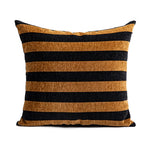 Coussin rayé noir et doré avec une texture soyeuse et élégante.