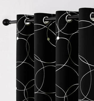 Zoom sur les œillets métalliques d’un rideau noir décoré de cercles blancs graphiques.
