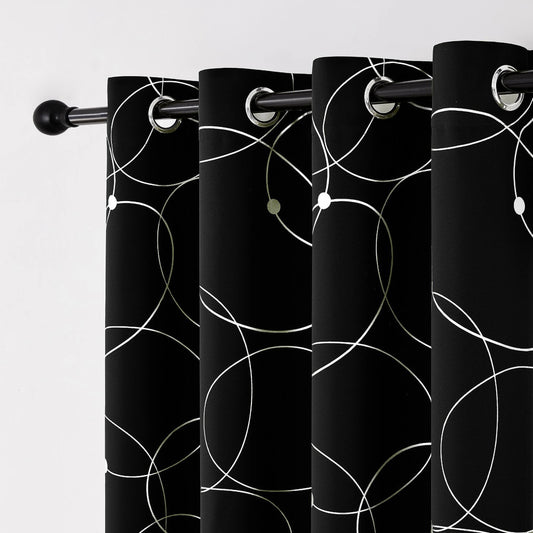 Zoom sur les œillets métalliques d’un rideau noir décoré de cercles blancs graphiques.