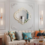 Le salon présente une décoration élégante avec un canapé capitonné beige, des coussins colorés et un miroir ornemental au mur.