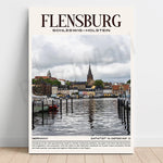 L'image montre le centre-ville de Flensburg, une ville portuaire allemande située dans le nord du Schleswig-Holstein, avec ses maisons colorées bordant le port et ses clochers dans le ciel nuageux.