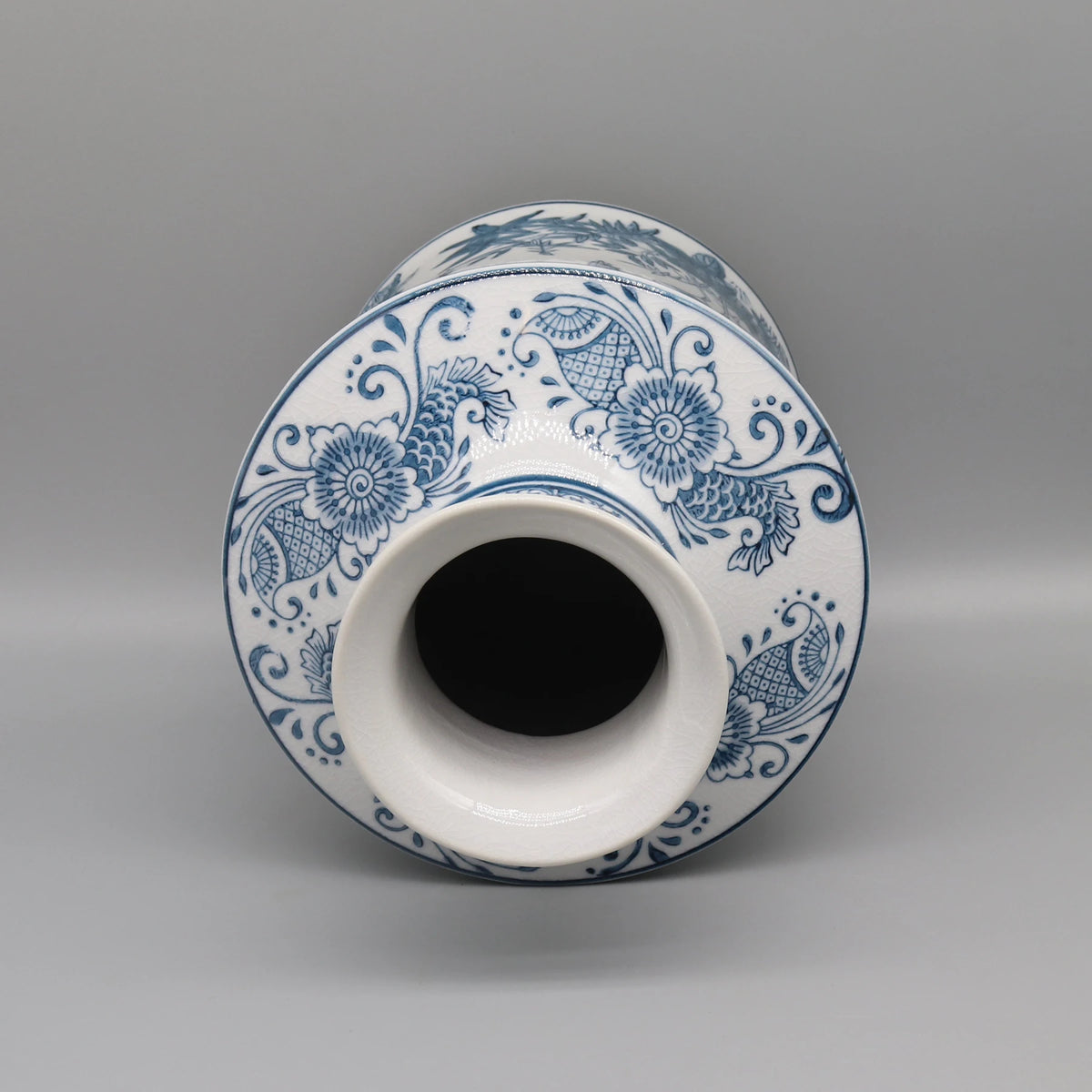 Vase en céramique blanc et bleu orné d'un motif floral et décoratif.