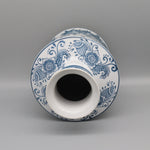 Vase en céramique blanc et bleu orné d'un motif floral et décoratif.