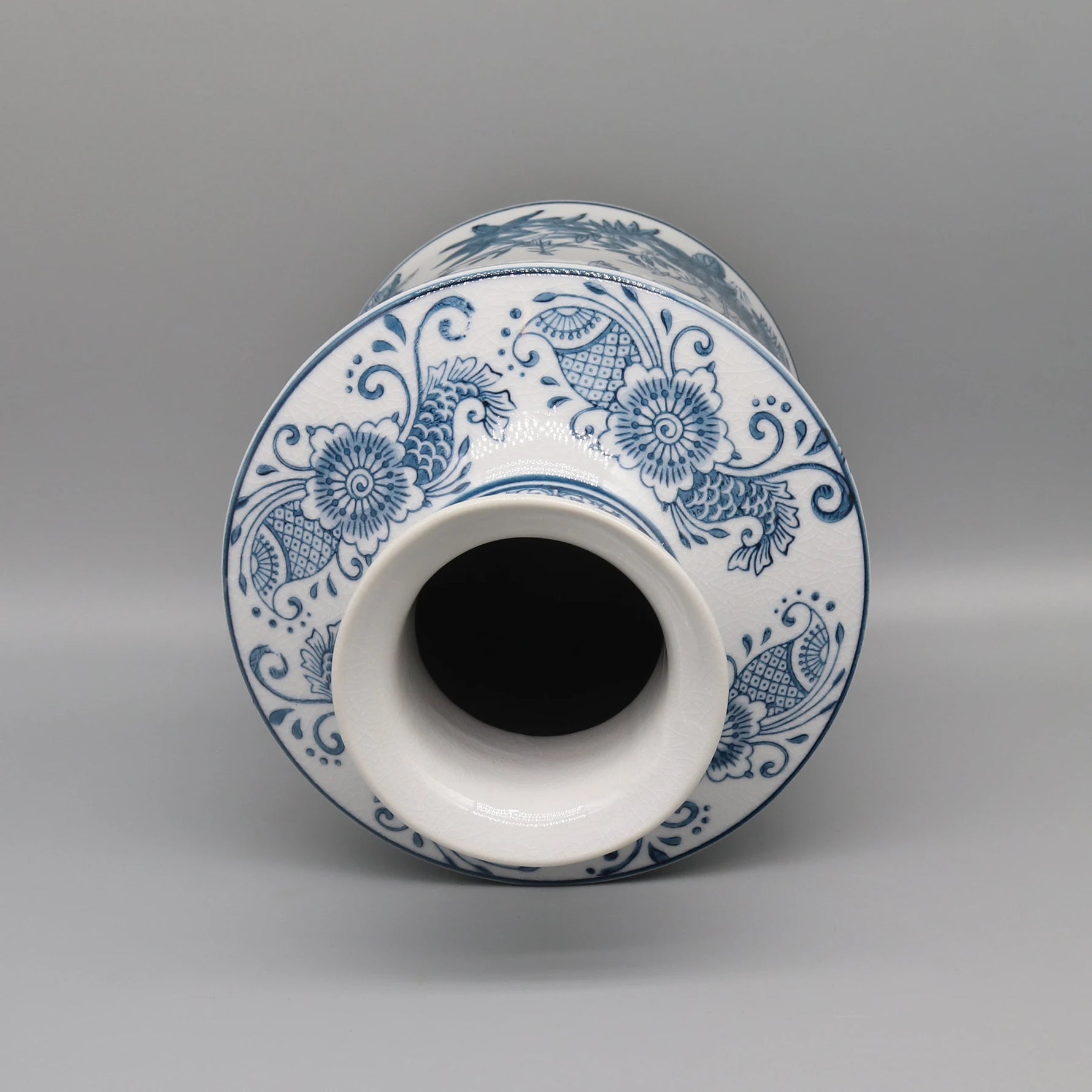 Vase en céramique blanc et bleu orné d'un motif floral et décoratif.