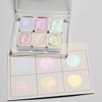 peintures aquarelle palette compacte bleu vert violet rose beige jaune blanc texture granuleuse opaques