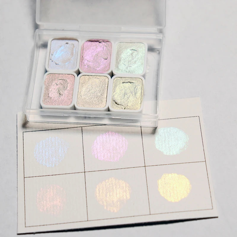 peintures aquarelle palette compacte bleu vert violet rose beige jaune blanc texture granuleuse opaques