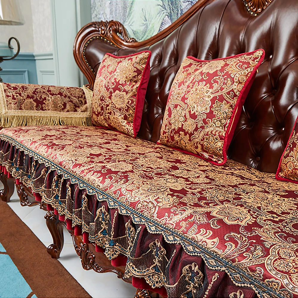Un canapé de style vintage richement orné de motifs floraux dorés et de pompons sur un fond bordeaux, offrant une élégance et une décoration luxueuse à cette pièce.