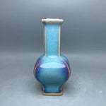 Vase en céramique de couleur bleue avec un dégradé subtil, présentant une forme élégante et épurée.