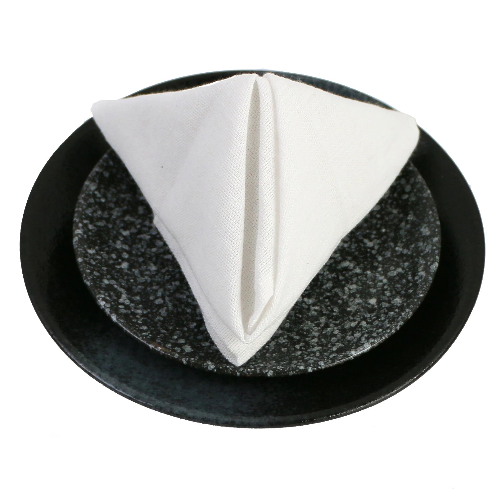 Une serviette blanche pliée repose sur un plat noir en pierre de lave.