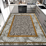 Tapis de cuisine avec motif floral et feuillage géométrique dans des nuances de beige, gris et doré, posé sur un sol carrelé dans une cuisine moderne avec électroménagers noirs.