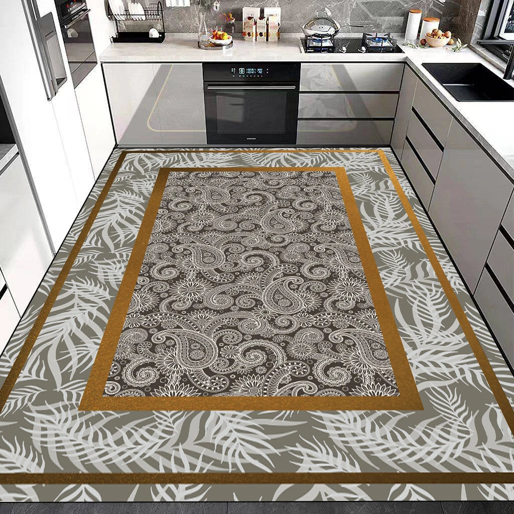 Tapis de cuisine avec motif floral et feuillage géométrique dans des nuances de beige, gris et doré, posé sur un sol carrelé dans une cuisine moderne avec électroménagers noirs.