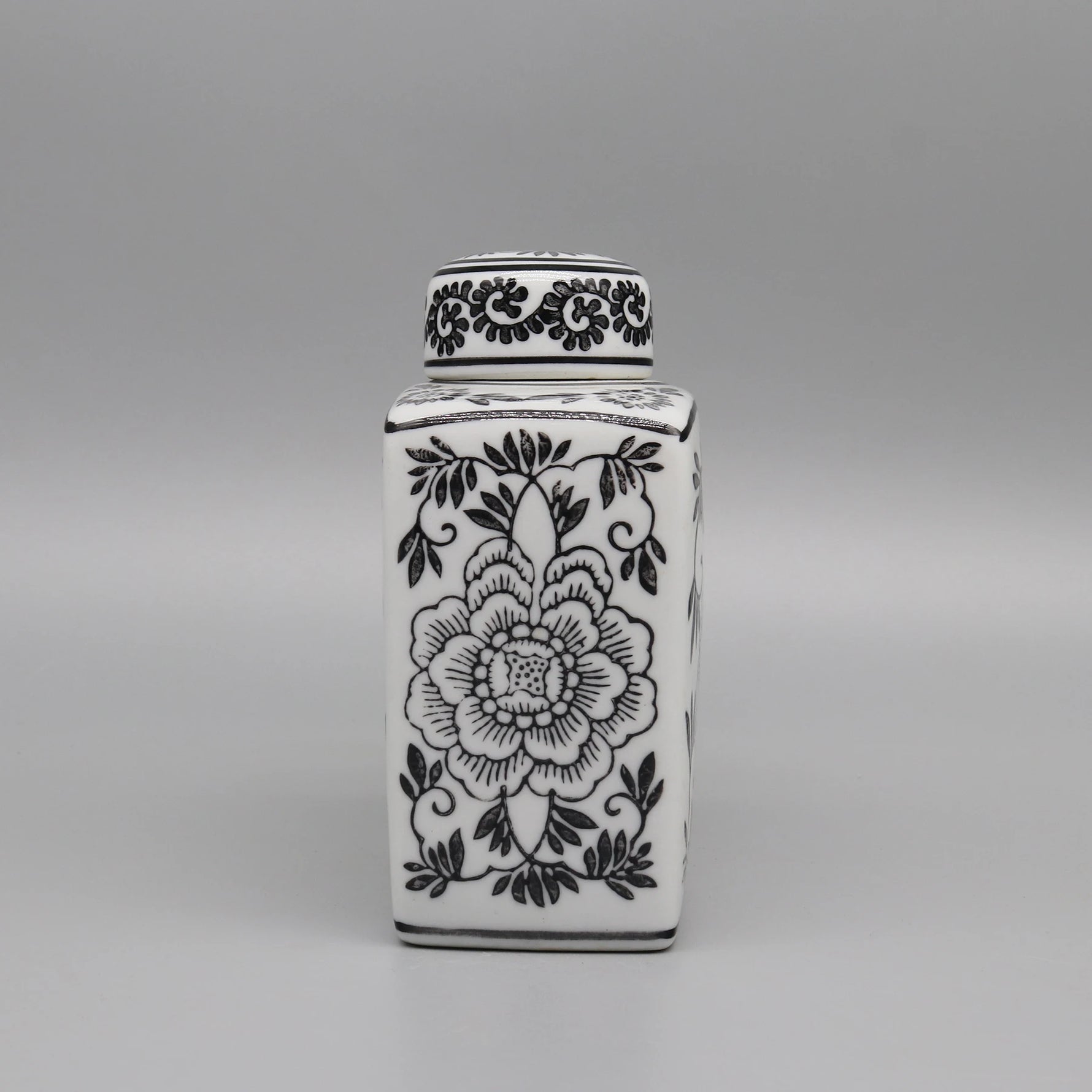 Vase décoratif en porcelaine blanche ornée de motifs floraux noirs élégants.