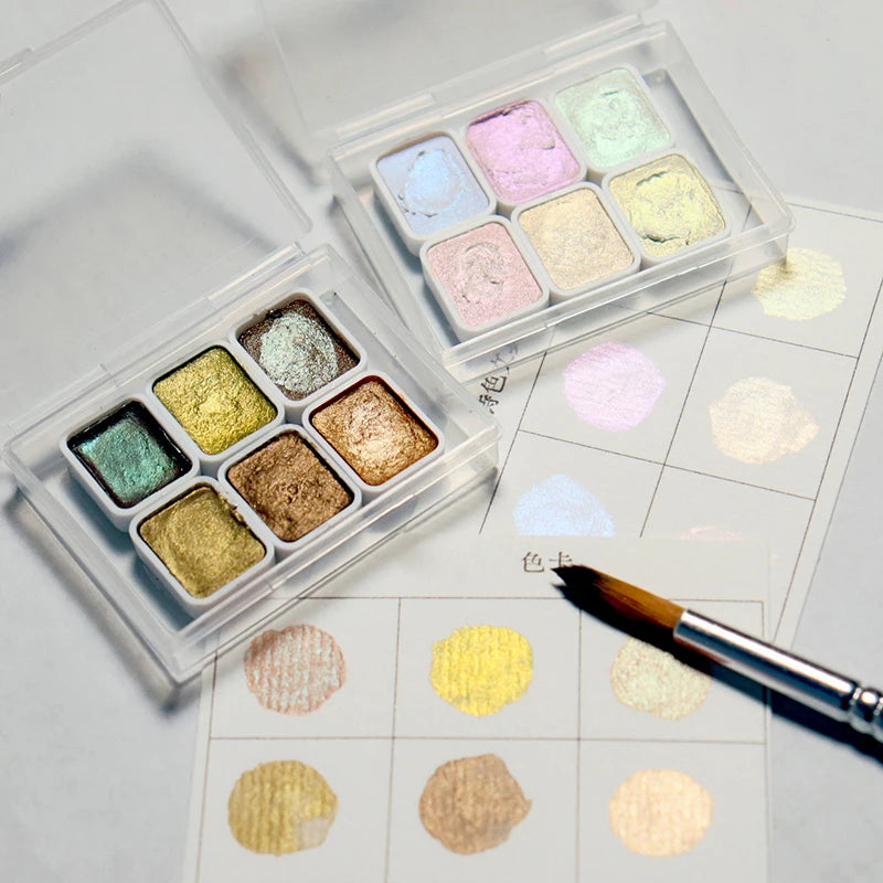 peintures aquarelle palette compacte bleu vert violet rose beige jaune blanc texture granuleuse opaques