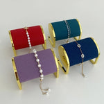 Présentoir bracelets et montres en métal doré sur table de chevet